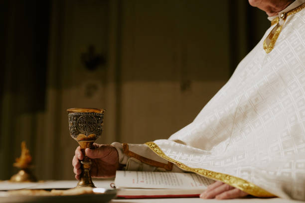 istock Pastor Putting Cup Of Wine On Communion Table 2155838071