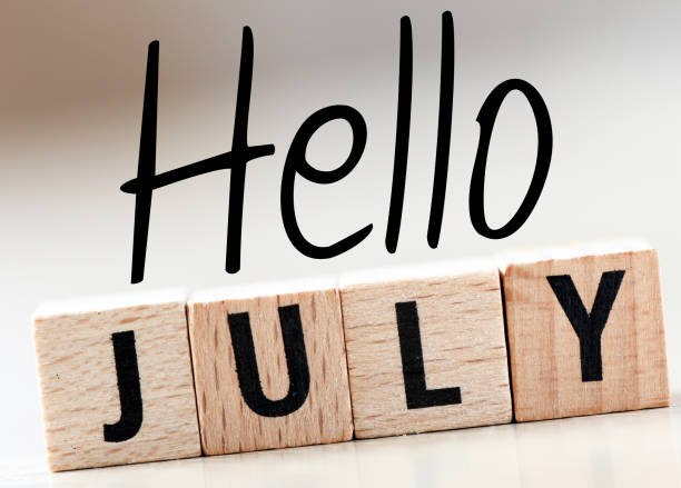 istock HELLO JULY word on a small chalk board on a light background. 2155843130