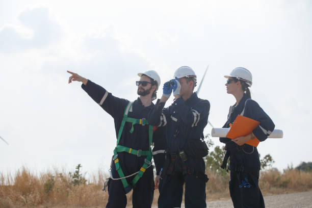 istock Team engineer wind turbine worker safety uniform survey discuss operational planning windmill field clean energy. Alternative technology protect environment reduce global warming problems. 2155845683