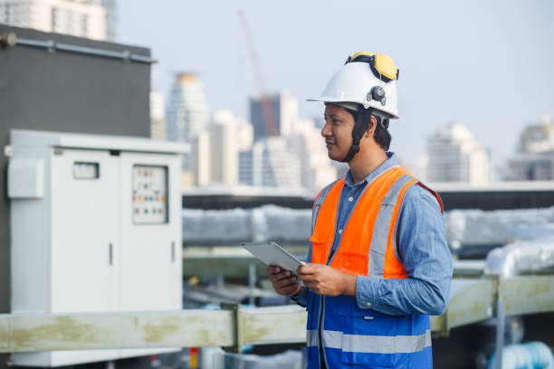 istock Asian man engineer holding tablet working at rooftop building construction. Male technician worker working checking hvac of office building. Engineering installing large air conditioning system. 2155848717