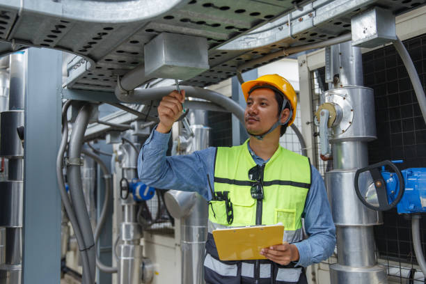 istock Male operator worker holding paperwork checking write record quality cooling air piping HVAC system at industrial building. Man engineer working on Heating Ventilation Air conditioning system. 2155848778