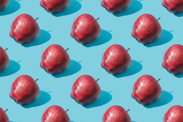 istock Seamless fruit pattern of fresh red apples on a blue background 2155850449