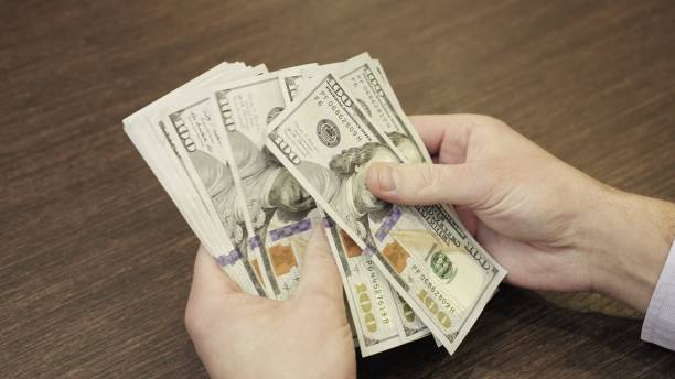 istock Man hands holding dollar money while recounting dollars. Slow motion 2155850653