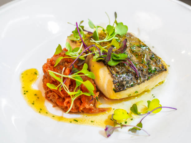 istock Hake Biscayan-style, garnished with watercress sprouts. 2155851101