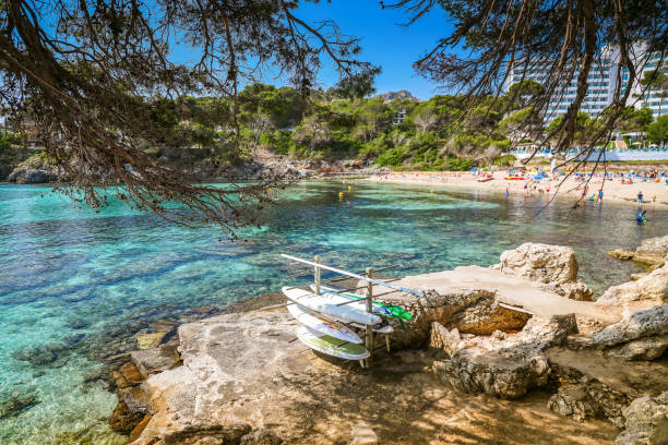 istock Peaceful panorama of Font de Sa Cala beach in Mallorca, featuring paddleboards perched on the rocky coast 2155861353