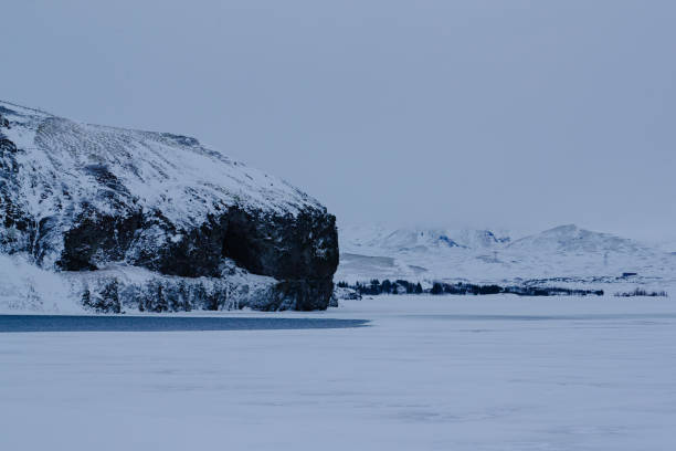 Snowy cliffside by a frozen lake