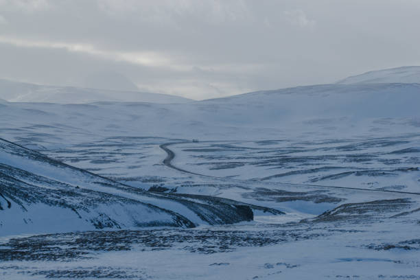 istock Winding winter road through snow-covered hills 2155865296