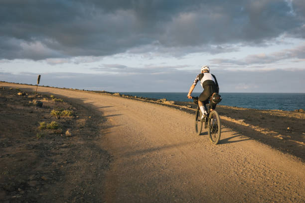istock Road bicyclist rides through desert landscape 2155866130