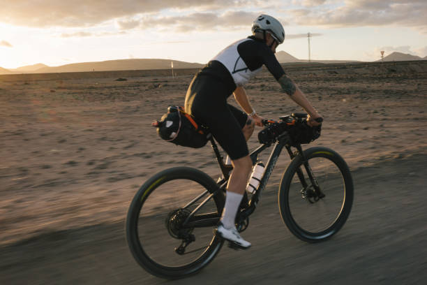 istock Road bicyclist rides through arid landscape 2155866167