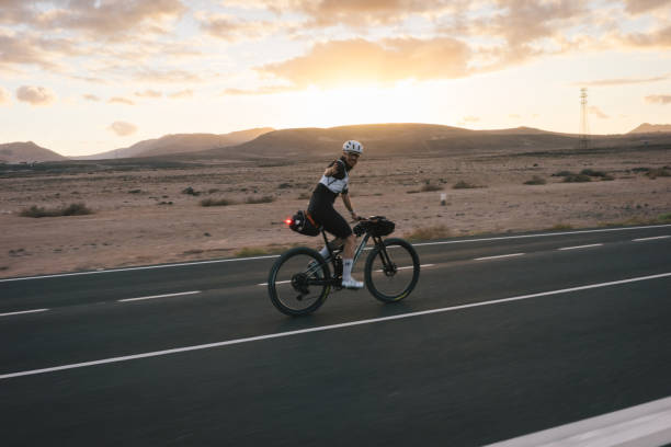 istock Road bicyclist rides through arid landscape 2155866215