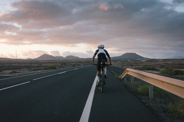istock Road bicyclist rides through arid landscape 2155866247