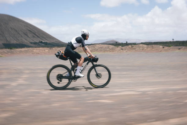 istock Road bicyclist rides through rural landscape 2155866609