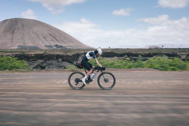 istock Road bicyclist rides through rural landscape 2155866638
