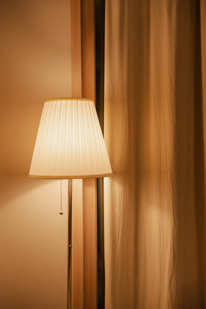 istock Elegant floor lamp beside beige curtains 2155866889