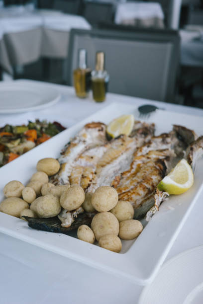 Food. Ready delicious dinner fish meat with salad and potatoes on kitchen home table. Meal time. Indoor.
