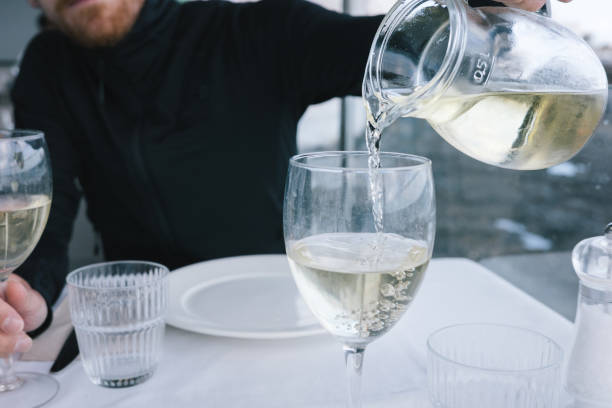istock Man pours wine into glass 2155867020