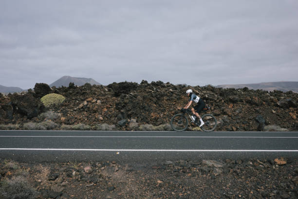 istock Road bicyclist rides through rural landscape 2155867069