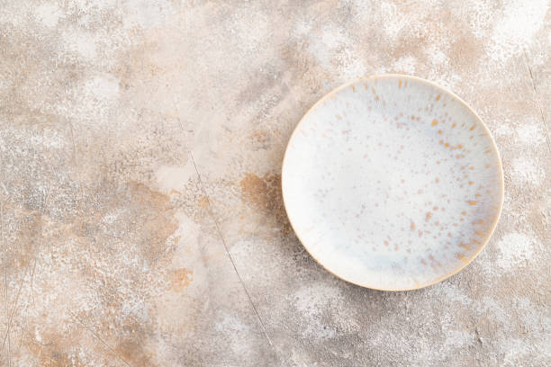 istock Empty blue and gold ceramic plate on brown concrete background. Top view, copy space 2155868097