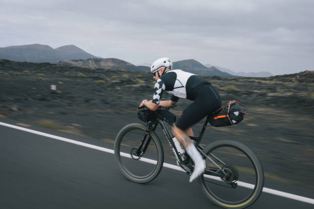 istock Road bicyclist rides through desert landscape 2155869728