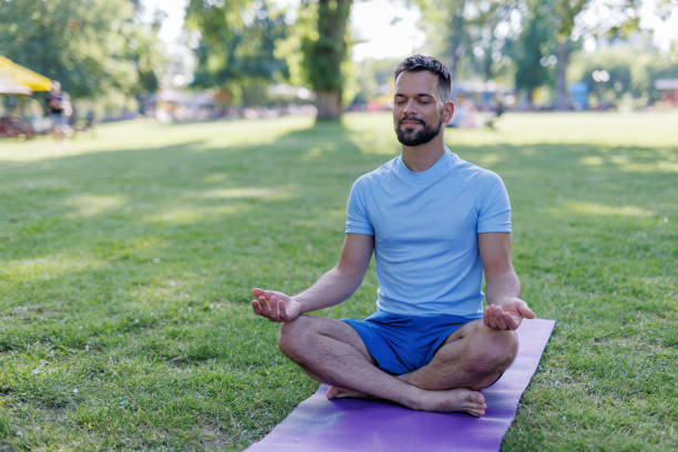 istock Man meditating in a park on a sunny day 2155870058