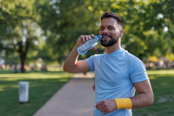 istock Man drinking water after workout in park 2155870225
