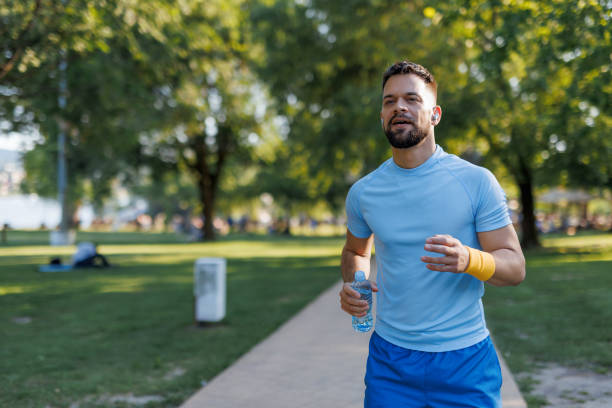 istock Focused athlete running with bottle of water 2155870268