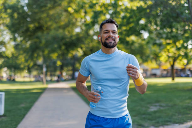istock Happy runner with earphones in summer park 2155870278
