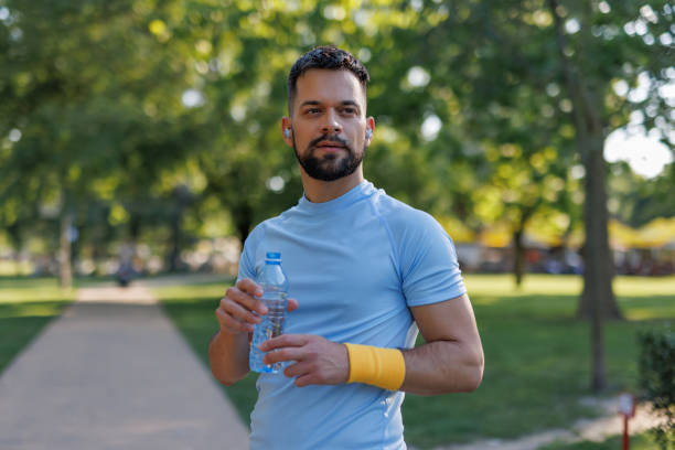 istock Focused athlete with water bottle in park 2155870336