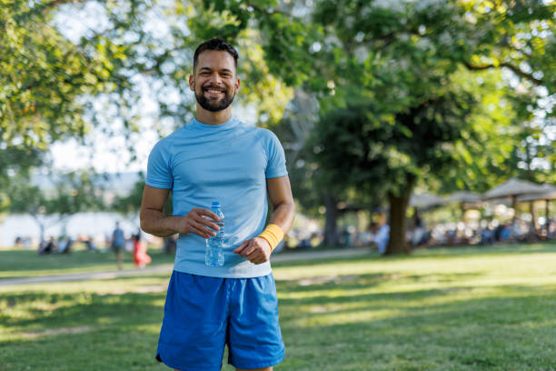 istock Man smiling with water bottle outdoors 2155870346