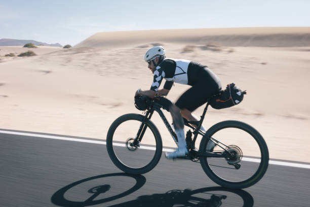 istock Bicyclist rides road through desert landscape 2155871330