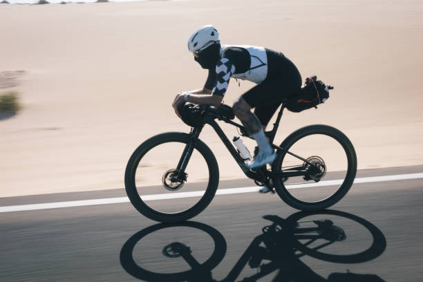 istock Bicyclist rides road through desert landscape 2155871413