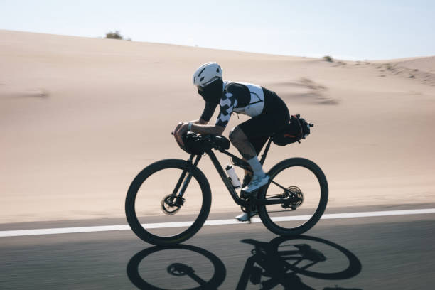 istock Bicyclist rides road through desert landscape 2155871414