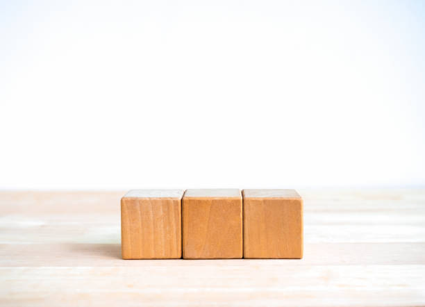 istock 3 wood blocks isolated on wooden table, white banner background with copy space. Empty blank template three cubes arranged in horizontal row for your text or icon for business, education concept. 2155872498