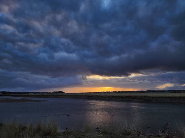 istock Cloudy sky at sunset above the serene river 2155875799