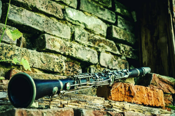 Old and dirty magic clarinet on a background of a beautiful old broken brick wall as symbol of beautiful classical music. Copy space for text or design.