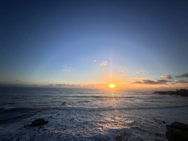 istock Sunset over ocean with rocks in the foreground 2155877306