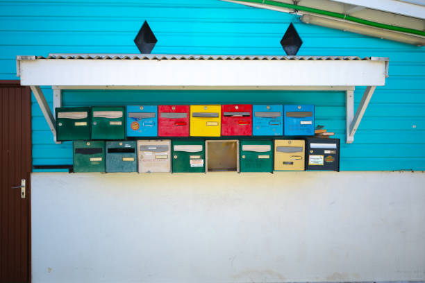 Sainte Anne, France – March 31, 2024: A bunch of colorful Mailboxes on wall shelf