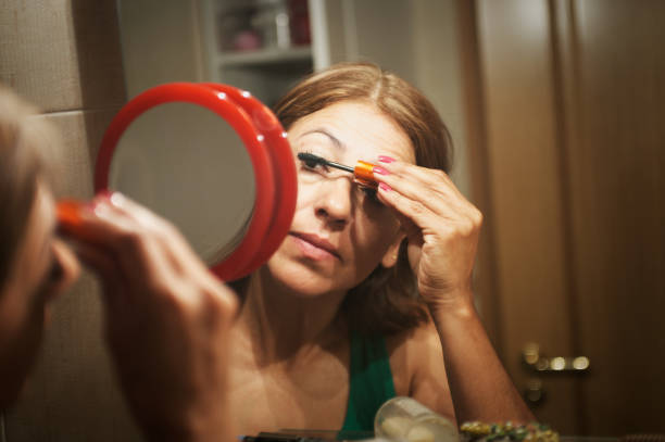 A young woman enhancing her lashes with mascara during her beauty routine