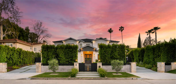istock a large house with some bushes around it and a sunset 2155879482