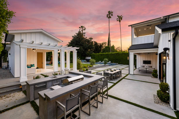 istock the outdoor kitchen with a fireplace, table and chairs at dusk 2155879513