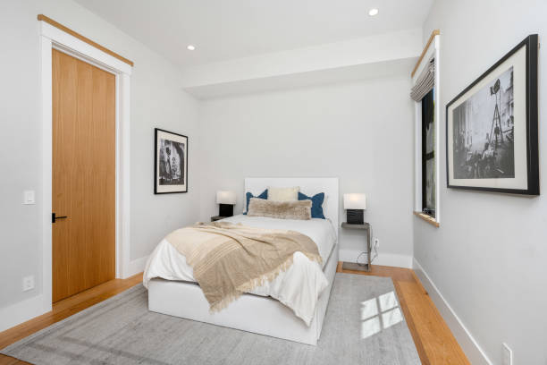istock a white bed in a room next to wooden doors and floor 2155879521