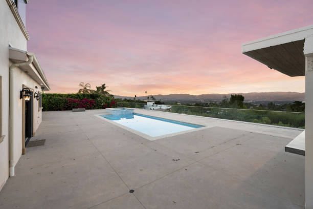 istock a large pool next to a white house with trees in the background 2155879541