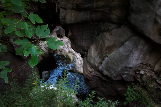 istock Creek flowing beneath a natural rock archway 2155881539