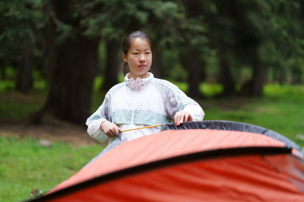 Asian junior high school students build tent in the forest
