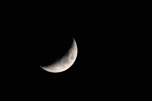 istock Half-lit moon shining in a dark sky at night. 2155882690