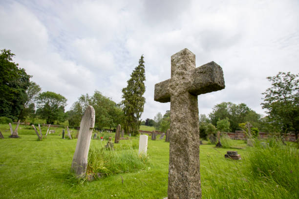 istock Cross-shaped gravestone in a church grounds 2155884404