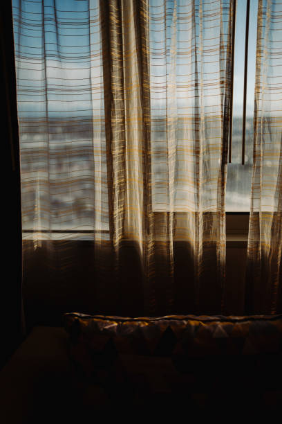 istock golden sunlight spills onto the curtains 2155885015