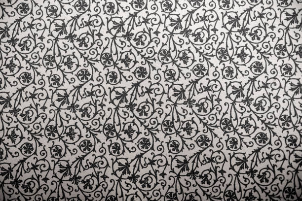 A vintage black and white wallpaper with ornate scrolls in an old-fashioned style