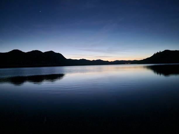 istock Tranquil lake with mountains under the evening sky 2155885972