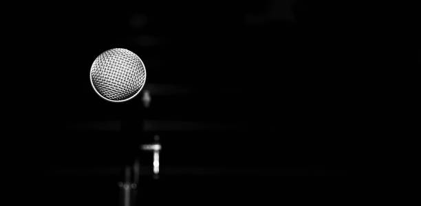 istock Public performance on stage microphone on stage against blured  background of concert hall. Black and white photo. 2155886158